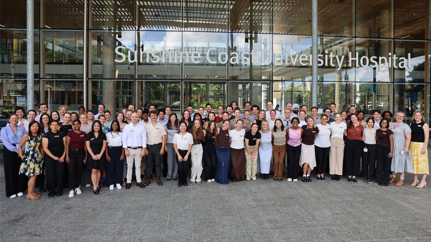 A large group of people standing outside the main entrance to Sunshine Coast University Hospital