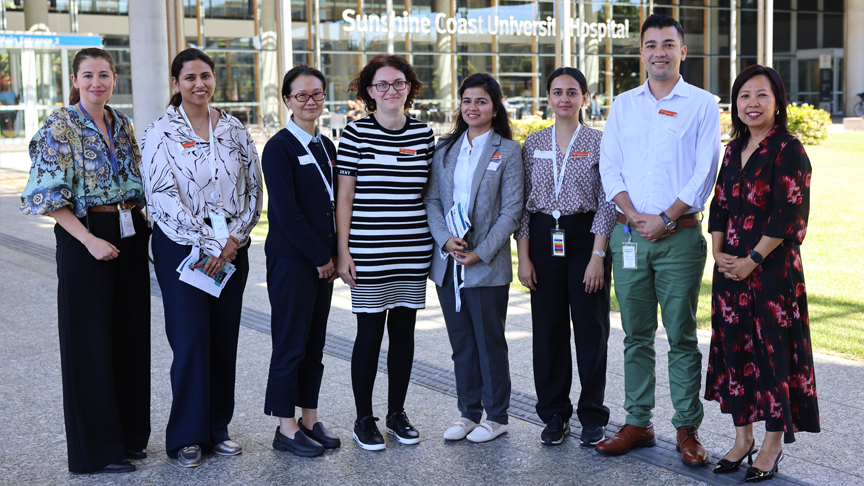 A group of 8 people standing outside the main entrance to Sunshine Coast University Hospital